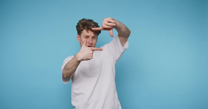 Man performs hand gestures in front of a blue background while showing different expressions in a creative display of communication