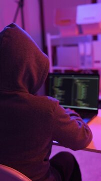 A mysterious hacker working on a computer in a dark room.