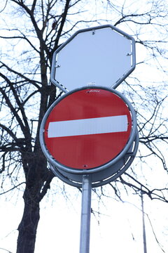 Panneau sens interdit sur fond de ciel et branches d&rsquo;arbre