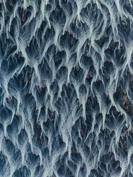 Aerial view of braided glacial rivers carving through the stark landscape, creating a tapestry of silver and charcoal that evokes the raw beauty of Iceland, Iceland.