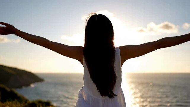 Woman with arms outstretched watching the sunset