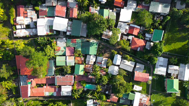 Aerial view of a vibrant tapestry of colorful rooftops nestled among lush green trees, a peaceful community thriving in nature's embrace, Tortuguero, Limon Province, Costa Rica.