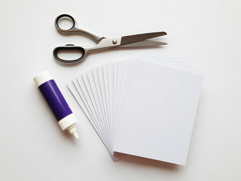 A neatly arranged flat lay of scissors, glue, and blank index cards on a clean surface.