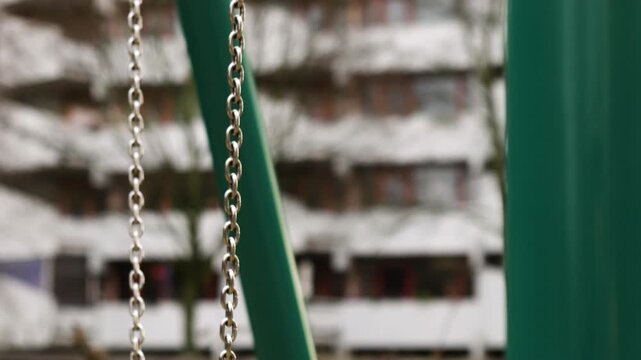 camera pan of empty swing in the playground