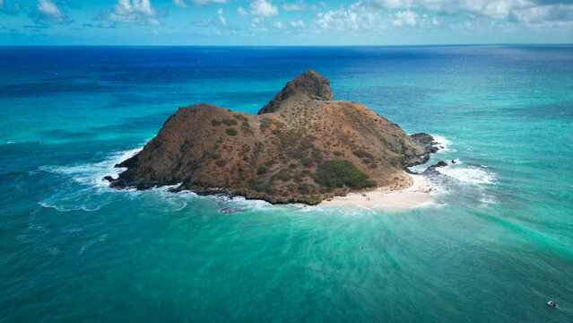 Aerial view of a rugged island with a prominent peak surrounded by turquoise waters and a sandy beach, Kailua, Hawaii, United States.