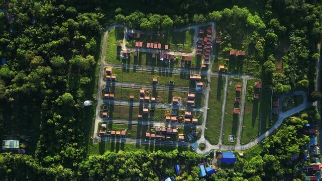 Expanding aerial shot revealing the full scale of a tropical housing development surrounded by nature at Camella Homes Alfonso Cavite Philippines