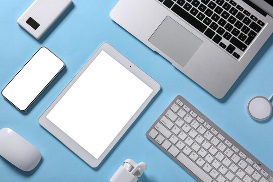Tablet computer with different modern gadgets on blue background
