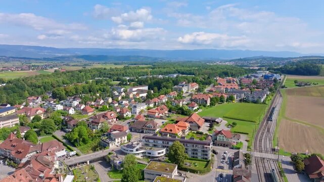 Smooth aerial drone flight over the eastern part of Aarberg, crossing the railway line toward the hospital in the Swiss Seeland region.