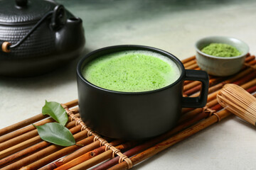 Cup of matcha tea with powder and chasen on grunge background, closeup © Pixel-Shot