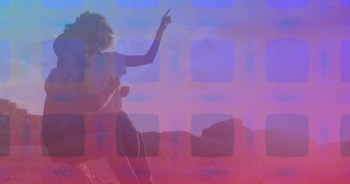 Pink square pattern over african american couple pointing towards a direction sitting on the rocks