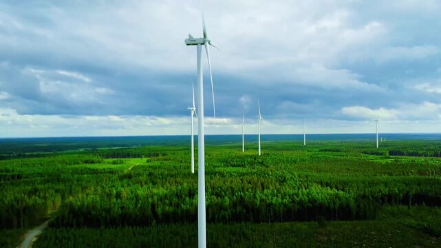 Aerial View of Wind Turbines Spanning Green Forests Under a Cloudy Sky in Nature in Finland