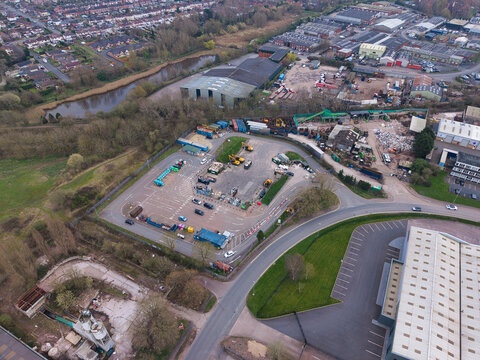Aerial view of a sprawling industrial landscape with metal buildings and parked vehicles next to a river, Dudley, United Kingdom.