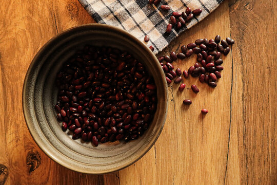 A deep, dark bowl filled halfway with dry beans
