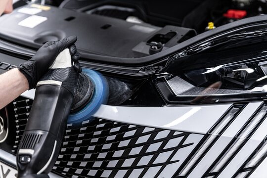 Car paint correction process with polishing machine in detailing studio removing scratches and restoring gloss. High quality photo