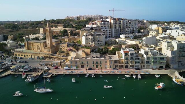 St Anne Church in Marsaskala, Malta, waterfront skyline, traditional buildings and boats