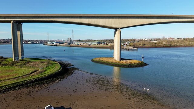 Aerial view of the Orwell Bridge spanning a wide river, its concrete pillars contrasting with the green banks, Ipswich, England, United Kingdom.