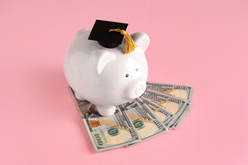 Piggy bank with graduation hat and money on pink background. Student loan concept