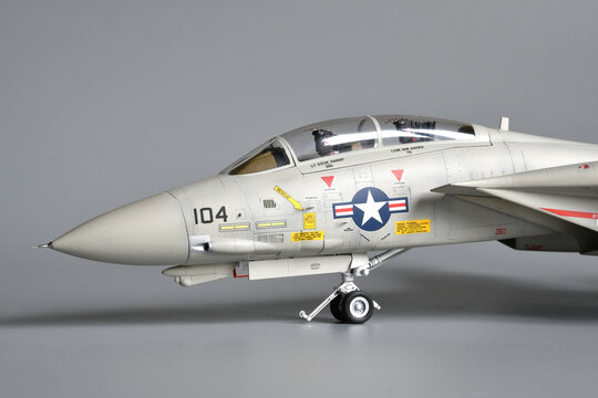Florence, Italy - April 1th 2026: Scale model of a fighter plane F-14A Tomcat on a grey background. Toy.