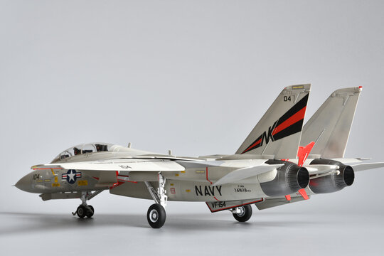 Florence, Italy - April 1th 2026: Scale model of a fighter plane F-14A Tomcat on a grey background. Toy.
