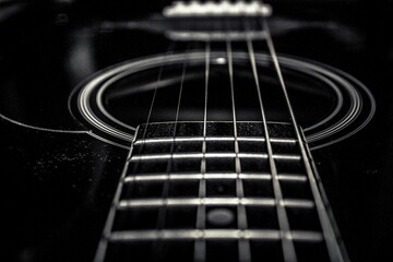Obraz premium Dramatic black and white macro of acoustic guitar strings and fretboard for music industry branding, artistic posters, or elegant concert advertising.