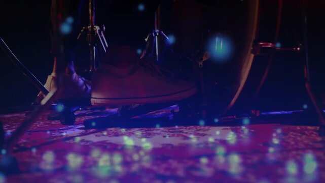 Musician's foot pressing bass drum pedal with floating blue lights maintaining steady music beat