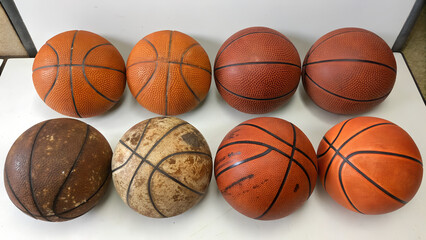 Obraz premium A single orange rubber basketball sits isolated as a round sports object on a white background, representing a classic team game equipment sphere for competition and leisure activity
