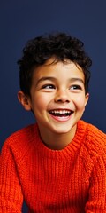Obraz premium Young boy smiling and laughing in portrait with blue background