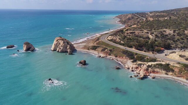 Aerial drone view of Aphrodite's Rock with turquoise sea and nearby coastal road, one of Cyprus' most famous natural landmarks