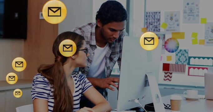 Animation of floating envelopes in circles over diverse workers planning over desktop at office