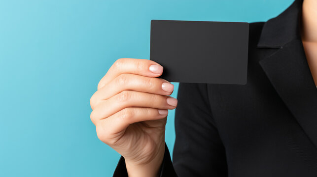 無地のカードを手に持ち提示する日本人ビジネス女性と青い背景のシネマティック広告ビジュアル