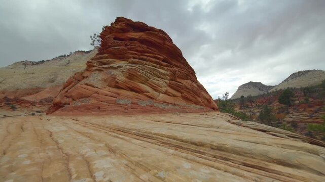 Footage of the dramatic landscape and towering sandstone cliffs within Zion National Park, Utah. The scene features the intricate, rust-hued layers of Navajo Sandstone, which show evidence of ancient 