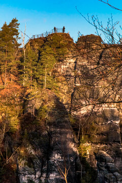 Beautiful close-up of the Ferdinandstein, part of the Wehlt&uuml;rme rock towers and a well-known viewpoint toward the Bastei Bridge, set against a blue winter sky at sunrise.