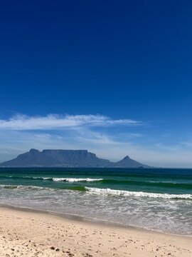Panoramic view of Table Mountain and the ocean from a sandy beach