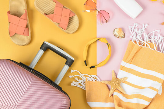 Composition with different beach accessories and suitcase on color background