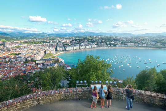 Tourists enjoying panoramic view of La Concha bay from Monte Urgull in San Sebastian, popular viewpoint in Basque Country, Spain