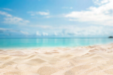 Obraz premium Panoramic nature background featuring a soft sandy beach in light tones. A bright and airy summer scene with a beautiful blurred turquoise ocean and blue sky in the background.