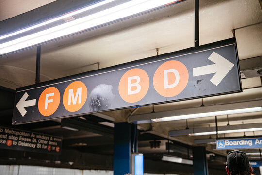 New York City, New York, USA - 08.03.2024: Overhead subway direction sign showing F M B and D train lines at Broadway Lafayette Street station in New York City. Underground metro scene with