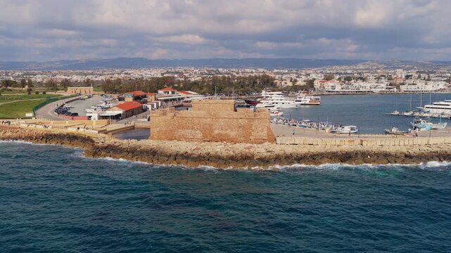 Aerial drone view of Paphos harbor with historic stone castle and boats along the waterfront