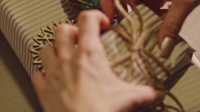 Woman's Hand Wrapping A Gift With A Rustic, Festive Theme. - closeup shot