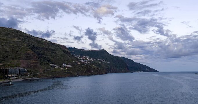 Beautiful golden sunset over the Atlantic Ocean and the cliffs of Calheta on the island of Madeira, Portugal. Aerial drone, hyperlapse timelapse, copy space