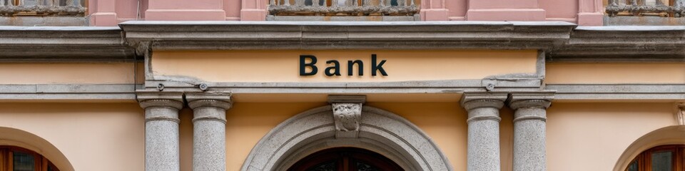 Fototapeta premium Bank pale yellow facade with granite columns arch entrance balcony balustrade classical urban architecture and decorative cornice