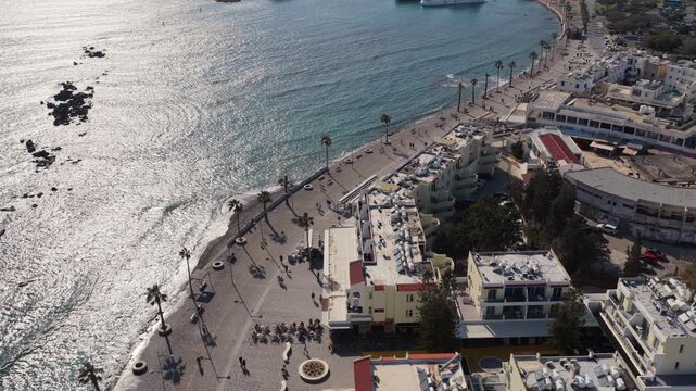 Aerial drone view of coastline promenade with sunlight reflecting on the Mediterranean Sea in Cyprus