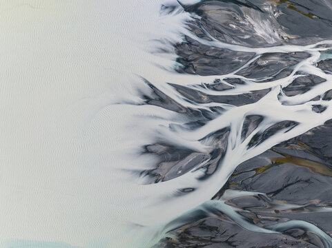 Aerial view of braided rivers intertwine like delicate silver threads across a canvas of rugged earth, Lake Tekapo, Canterbury Region, New Zealand.