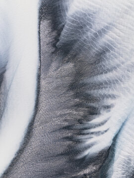 Aerial view of braided river channels meander across the landscape, creating a mesmerizing pattern of light and shadow, Lake Tekapo, New Zealand.