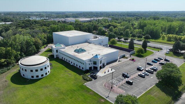 Aerial view of the pristine white building complex with a round structure and parking lot, nestled amidst a vibrant green landscape, Plymouth, Minnesota, United States.