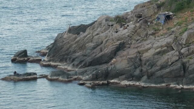 Remote offgrid survival shelter on a rugged rocky coastline makeshift hermit dwelling
