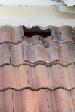 Damaged old roof tile in need of repair.