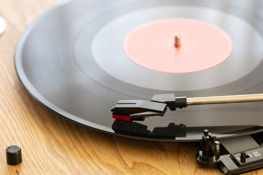 turntable with cartridge and 33 rpm vinyl record in the foreground