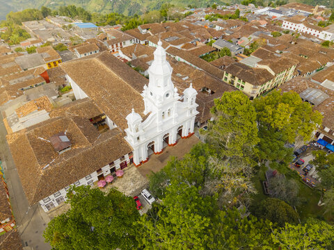Aerial view of the Immaculate Conception Cathedral stands gleaming white against the backdrop of terracotta roofs and verdant foliage, Salamina, Caldas, Colombia.