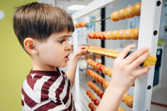 Focused boy using Abacus to practice basic math during school activity